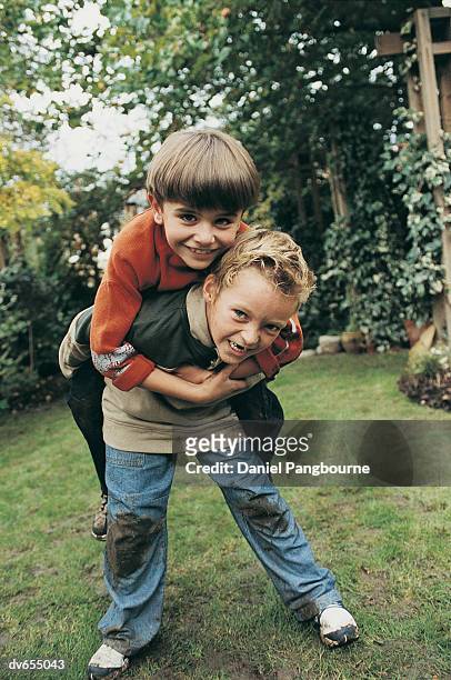 boy giving friend a piggyback - daniel stock pictures, royalty-free photos & images