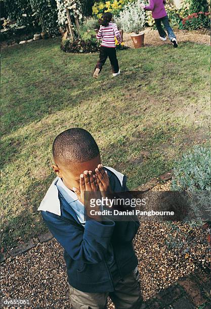 children playing hide and seek in a garden - daniel fotografías e imágenes de stock
