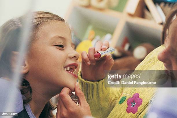 close-up of girl applying lipstick to her friend - daniel fotografías e imágenes de stock