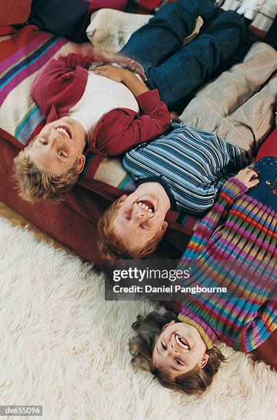 portrait of three children lying on a sofa - daniel stock pictures, royalty-free photos & images