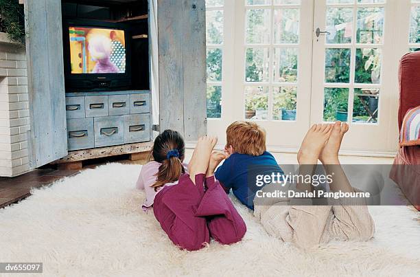 two children watching television - daniel fotografías e imágenes de stock