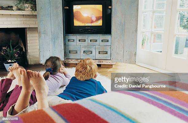 two children watching television - daniel fotografías e imágenes de stock