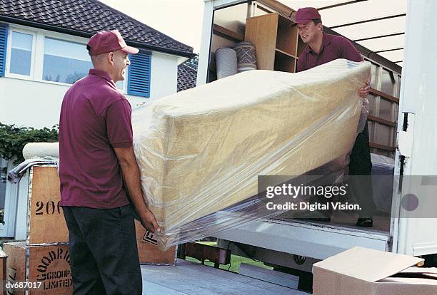 movers unloading moving van - carrying sofa stock pictures, royalty-free photos & images