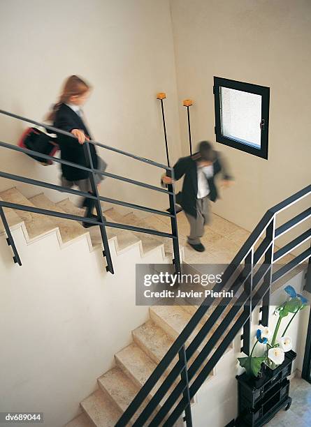 schoolboy and a schoolgirl running down stairs - step brother stock pictures, royalty-free photos & images