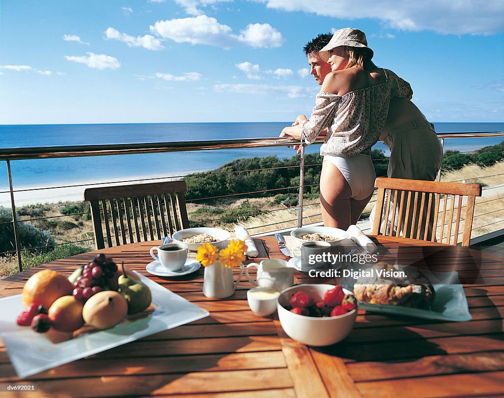 Couple Looking at the Sea with Their Breakfast in the Foreground