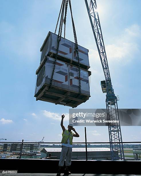 builder guiding crane with a mobile phone - mobile crane - fotografias e filmes do acervo