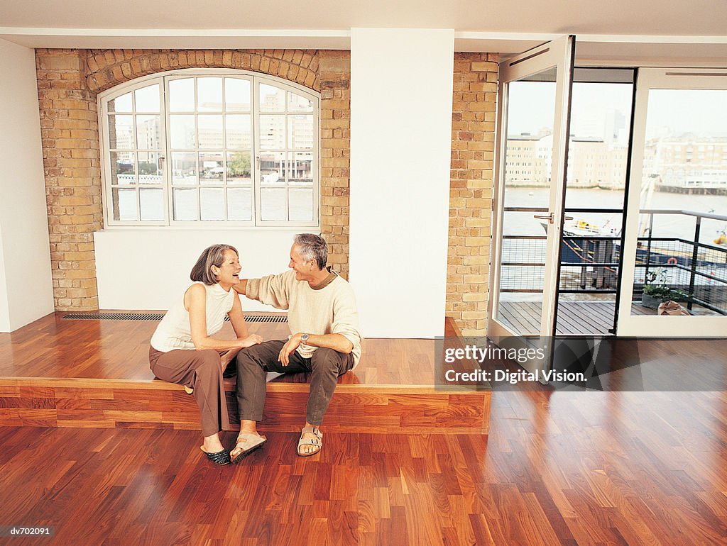 Mature Couple Sitting in Their Apartment and Laughing