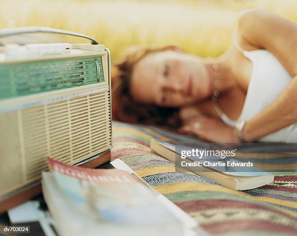 woman sleeping on a rug in the garden - portable radio stock pictures, royalty-free photos & images