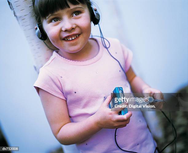 portrait of a young girl listening to her personal stereo - personal stereo photos et images de collection