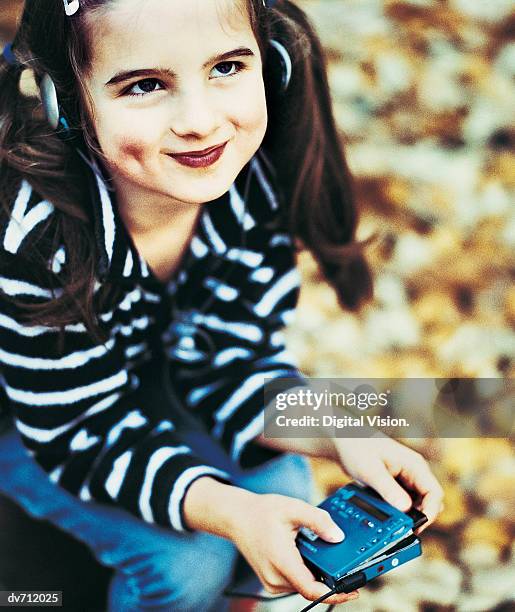 portrait of a young girl listening to her personal stereo - personal stereo photos et images de collection