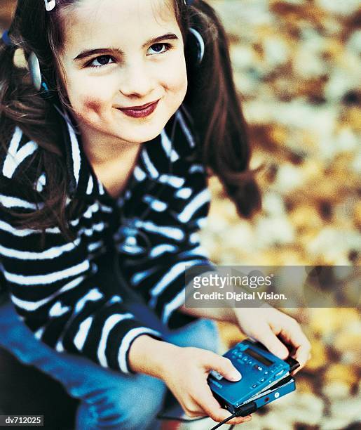 portrait of a young girl listening to her personal stereo - personal stereo stockfoto's en -beelden