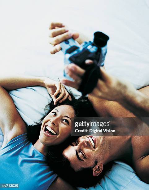 couple using a digital video camera to record themselves - digital camcorder stock pictures, royalty-free photos & images