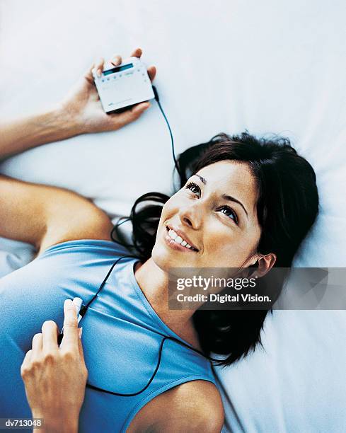 woman relaxing and listening to her personal stereo - personal stereo photos et images de collection