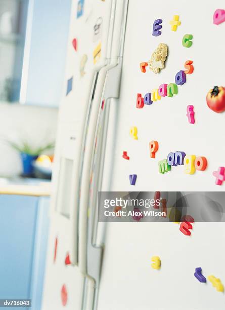 fridge magnets on a refrigerator - 英字マグネット ストックフォトと画像