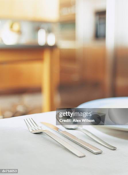 knife, fork and a spoon next to a plate - wilson stock-fotos und bilder