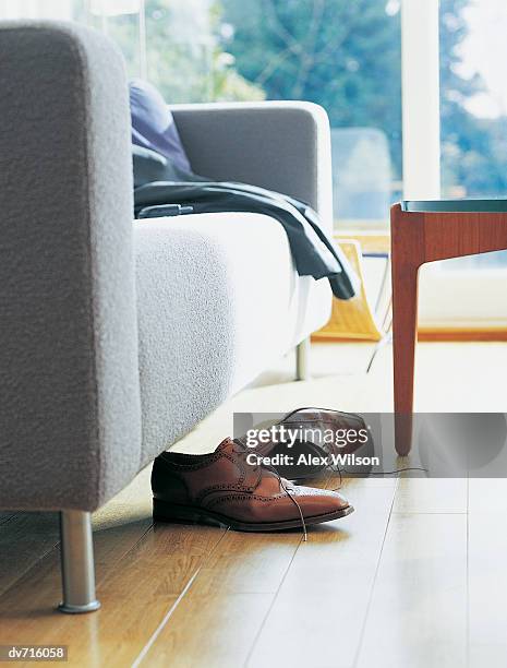 shoes by a sofa and a table - wilson stock-fotos und bilder