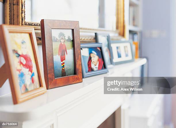 photographs on a mantelpiece - repisa de chimenea fotografías e imágenes de stock