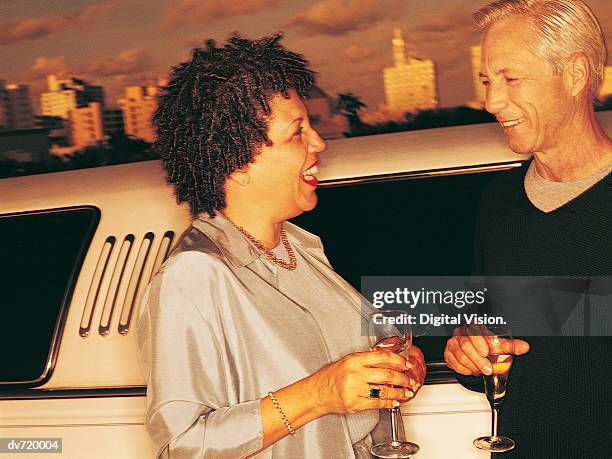 mature couple standing beside limousine holding glasses of wine - digital devices beside each other bildbanksfoton och bilder