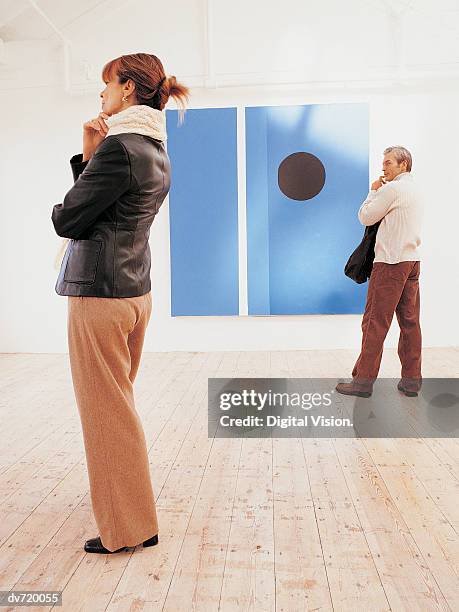 man and woman in an art gallery - gallery 2 stock pictures, royalty-free photos & images
