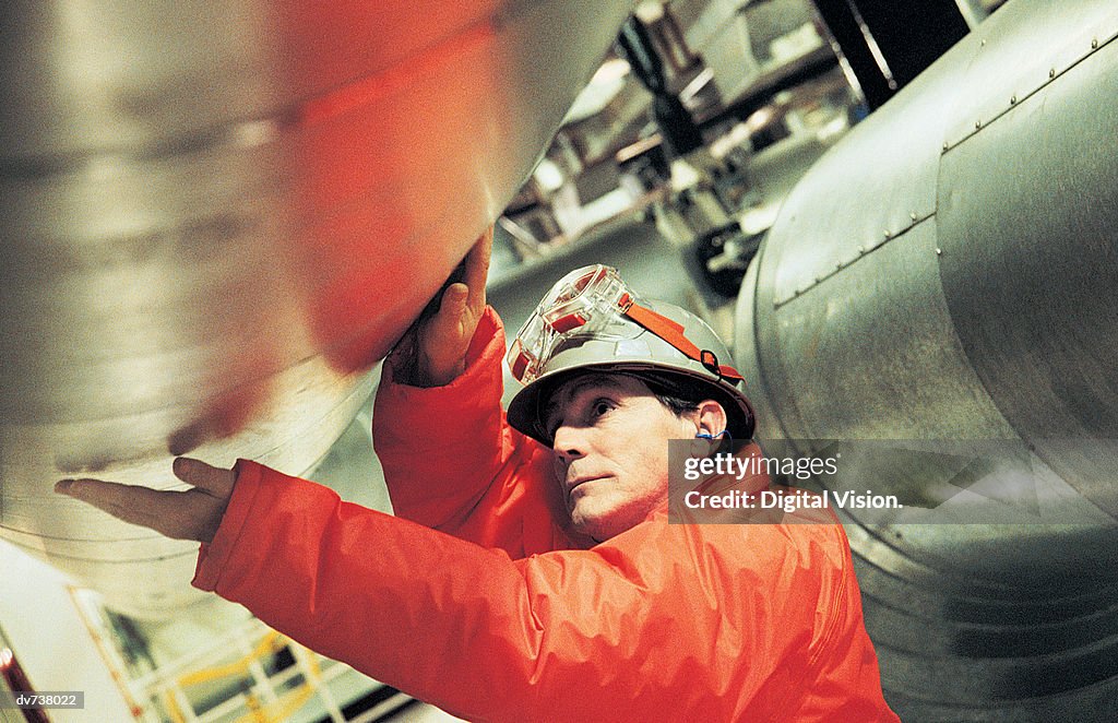 Engineer touching pipe in nuclear power station