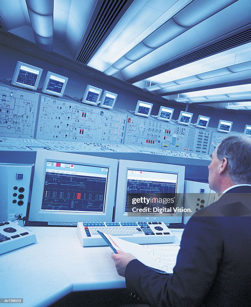Engineer sitting at control panel of nuclear power station