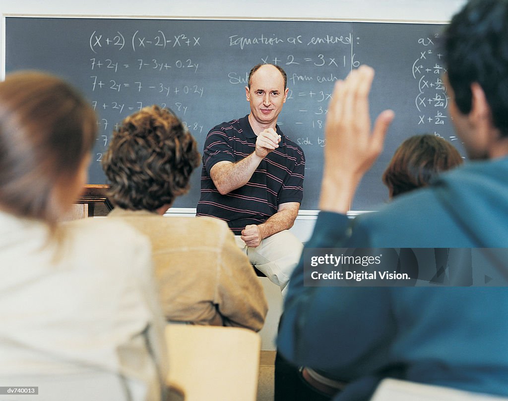 Male Teacher Asking Students Questions During Seminar