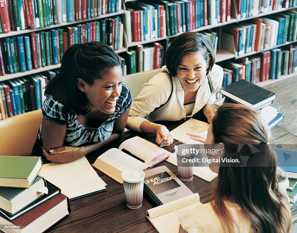 Talking In The Library Three Female Students Talking In A Library High-Res Stock Photo - Getty ...