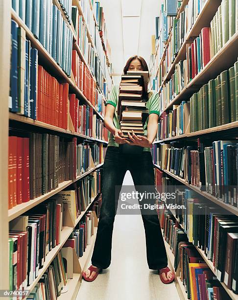 female student holding a pile of books - college student holding books stock pictures, royalty-free photos & images