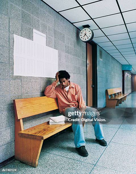 male student sitting on bench, disappointed after exam results - 合格発表　掲示板 ストックフォトと画像