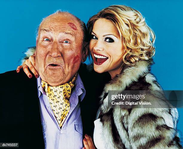 portrait of a woman with her arm around a wealthy senior man - old man young woman stockfoto's en -beelden