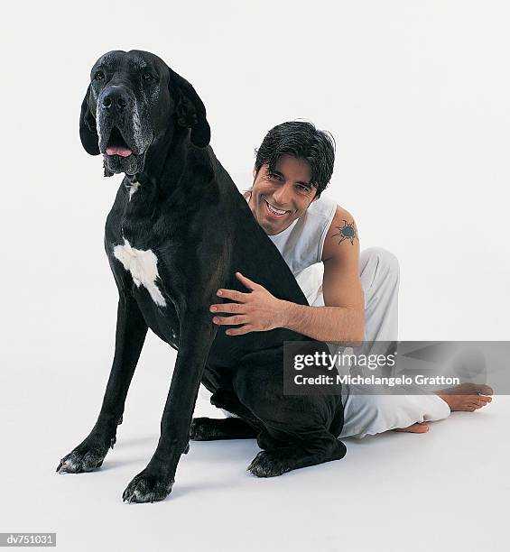 portrait of a man sitting next to his great dane - dogge stock-fotos und bilder