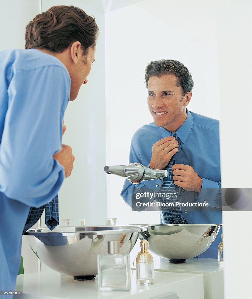 Reflection of a Businessman Arranging His Tie in the Mirror