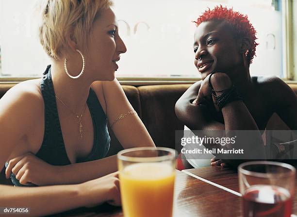 two women talking in a bar - women talking stock pictures, royalty-free photos & images