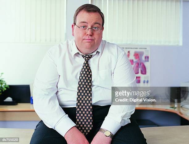 portrait of an overweight businessman in a doctor's office - cardiopatía fotografías e imágenes de stock