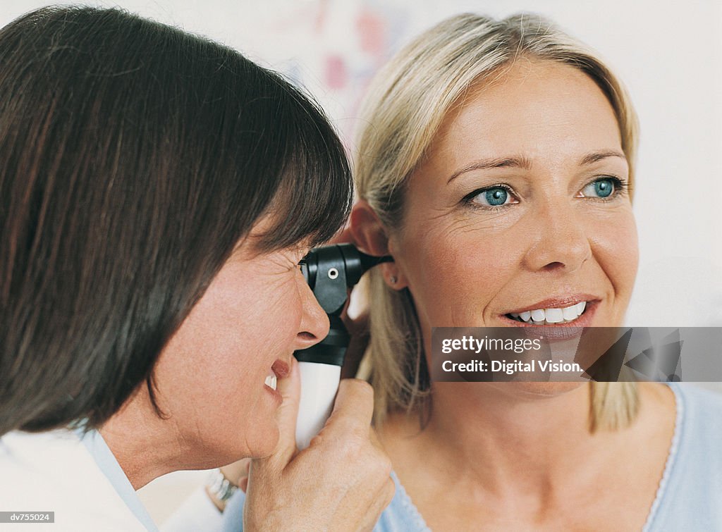 Doctor Examining Patient's Ear with Otoscope