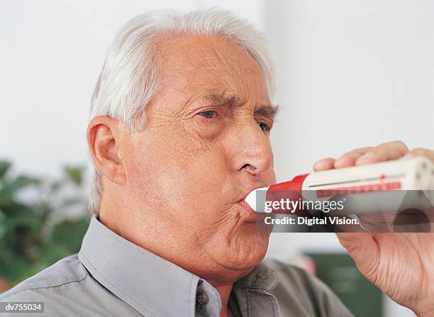 elderly male patient using spirometer device - spirometer stock pictures, royalty-free photos & images