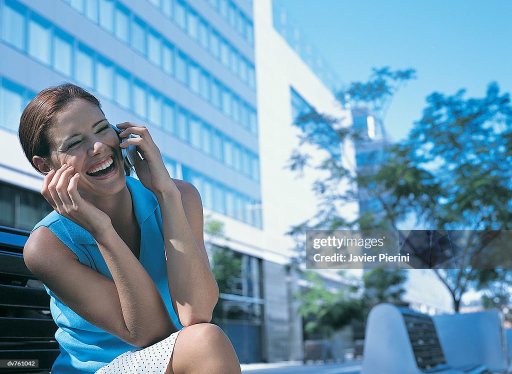 Businesswoman Sitting Outdoors Using Her Mobile Phone