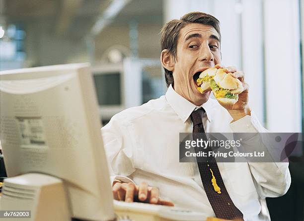 businessman eating at his desk with a mustard stain on his tie - white shirt stain stock pictures, royalty-free photos & images