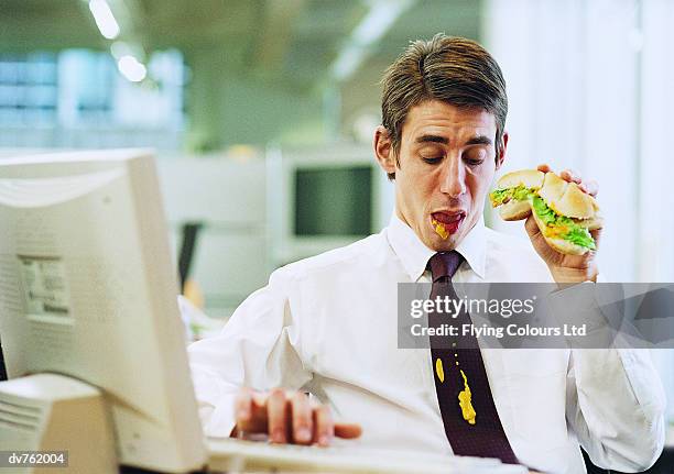 businessman at work looking down at his mustard stained tie - food stains stock pictures, royalty-free photos & images