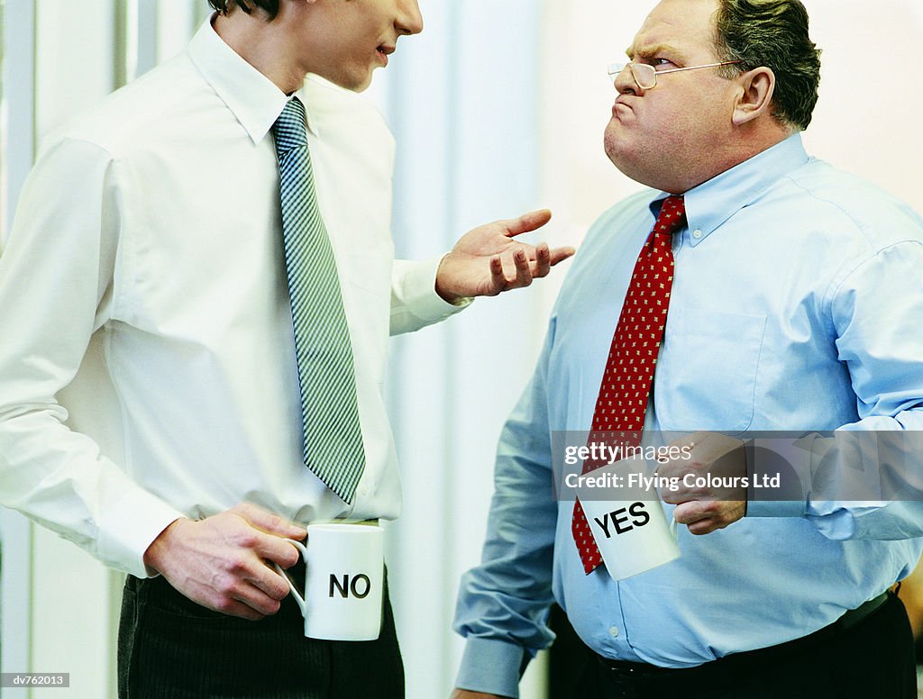 Two Businessmen Arguing With Both of Them Holding Mugs Labelled 'Yes' and 'No'