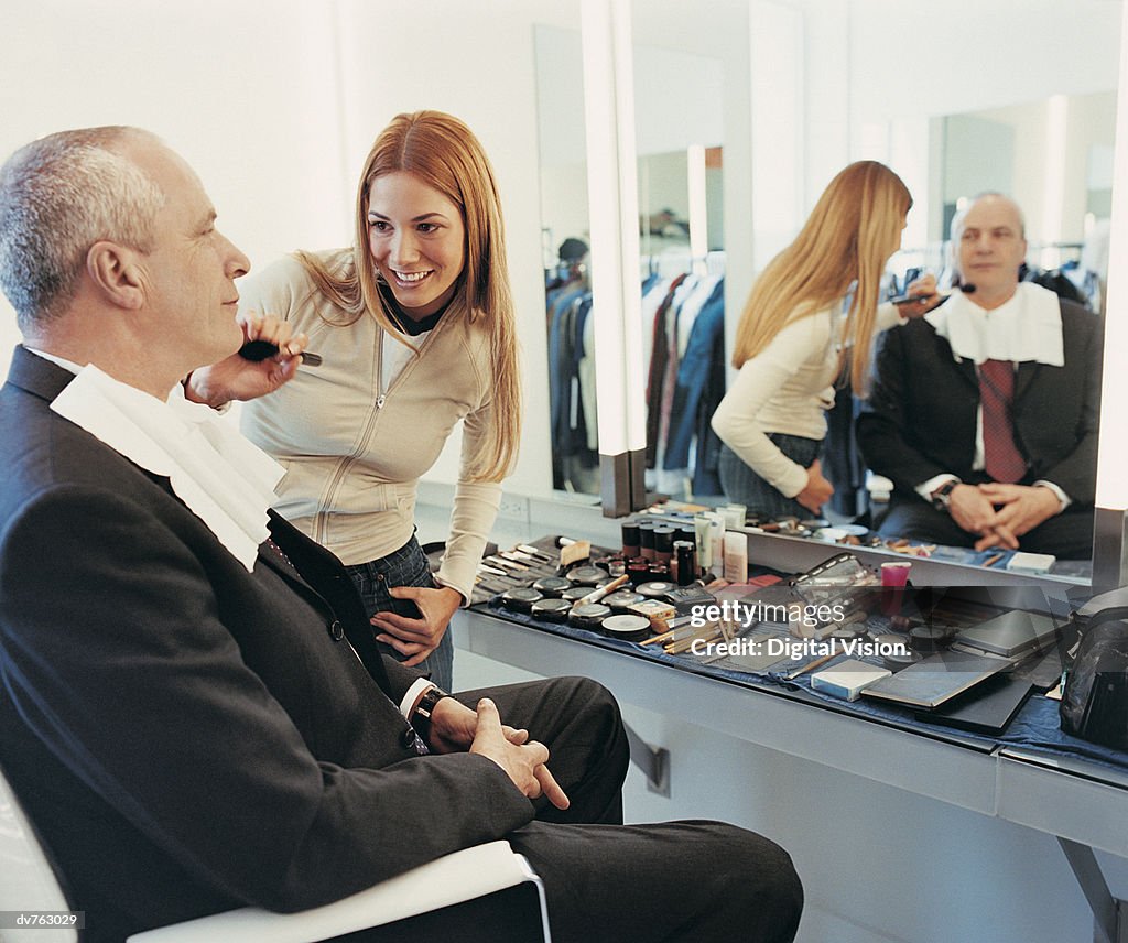 TV Presenter Receiving a Brushing of Foundation From a Makeup Artist in the Dressing Room of a TV Studio
