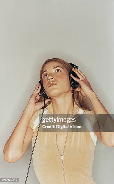 young woman listening to music on headphones - estroboscópio circular imagens e fotografias de stock
