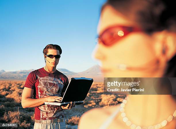 couple using laptop in the desert - laptop desert stock pictures, royalty-free photos & images