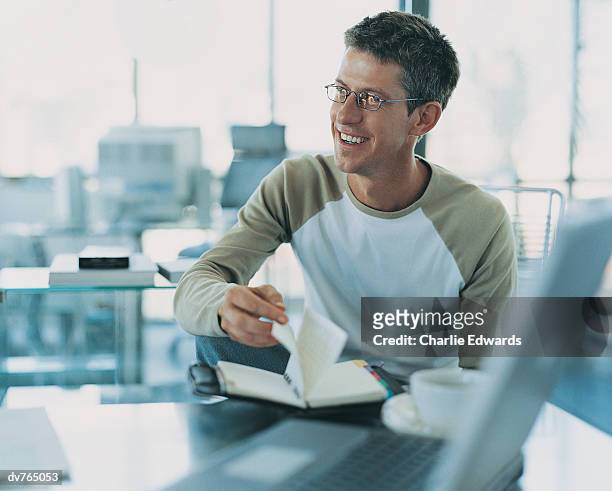 businessman sitting at his desk and turning the pages of his personal organiser - pages of president george washingtons first inaugural address on in u s capitol building stockfoto's en -beelden