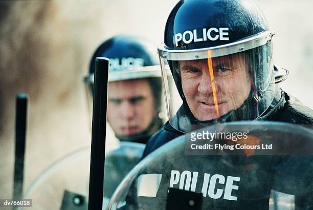 police in a riot holding shields and truncheons - emergency services equipment stock pictures, royalty-free photos & images
