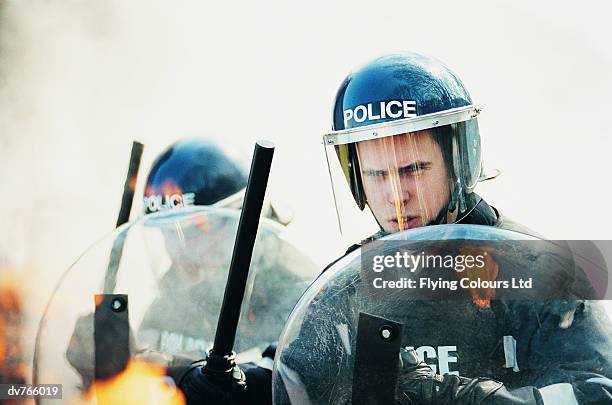 police in a riot holding shields and truncheons - emergency services equipment stock pictures, royalty-free photos & images