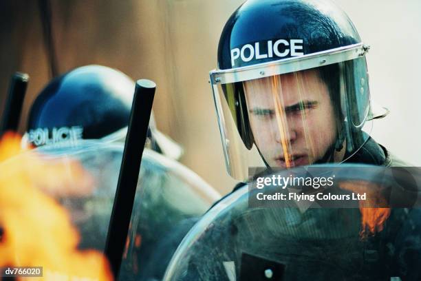 police in a riot holding shields and truncheons - emergency services equipment stock pictures, royalty-free photos & images