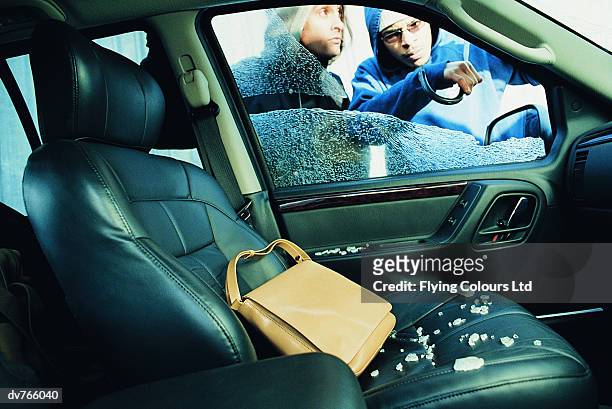 male robbers breaking into a car to steal a handbag - five arrested in delhi after shootout between police and gang of car jackers stockfoto's en -beelden