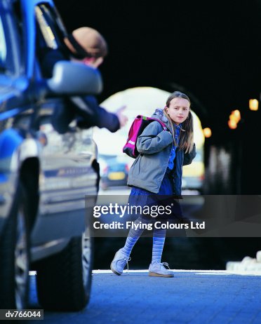 Man in a Car Beckoning an Apprehensive Girl Standing in a City Street Man in a Car Beckoning an Apprehensive Girl Standing in a City Street