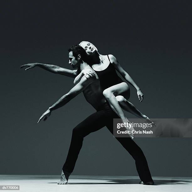 female dancer holding onto the back of a male dancer - black and white leotard stock pictures, royalty-free photos & images